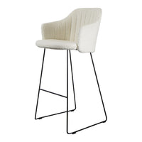 Cream-colored upholstered bar stool with ribbed texture and black metal legs. Perfect for modern decor.