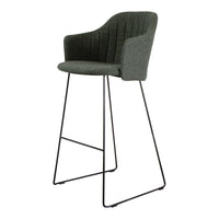 Stylish dark green upholstered bar stool with vertical quilted pattern and sleek black metal legs.