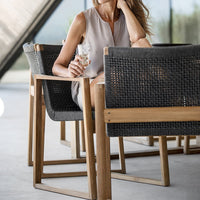 "Elegant beige and gray woven outdoor chairs with wooden frames, set against a modern backdrop."