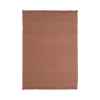 "Solid terracotta area rug with fringe edges for a warm, cozy touch in any space."
