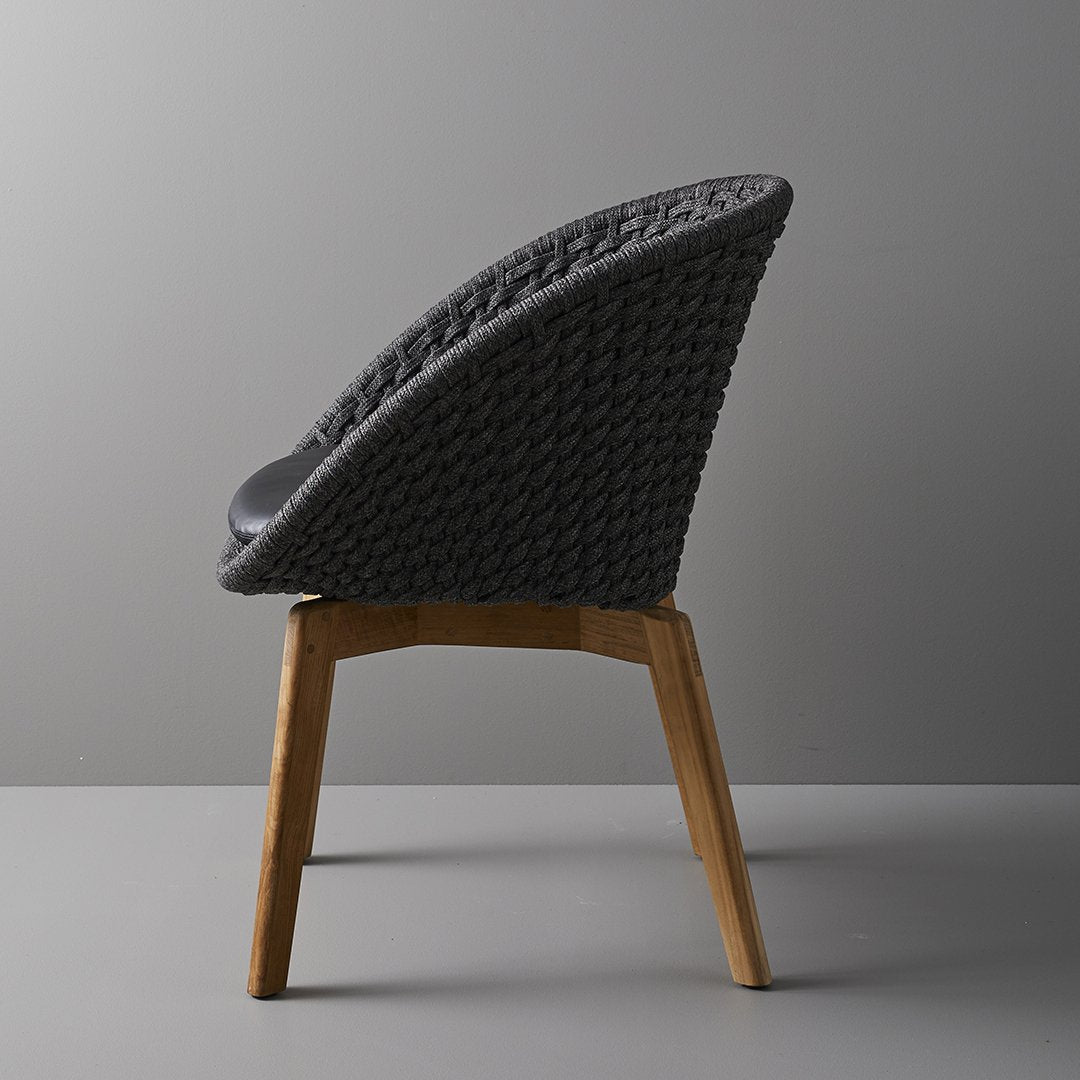 Chair with woven backrest and wooden legs on a gray background