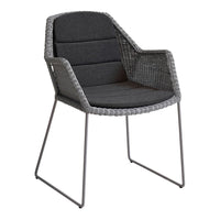 Gray woven chair with sleek metal legs and a cushioned seat, blending modern and cozy design elements.
