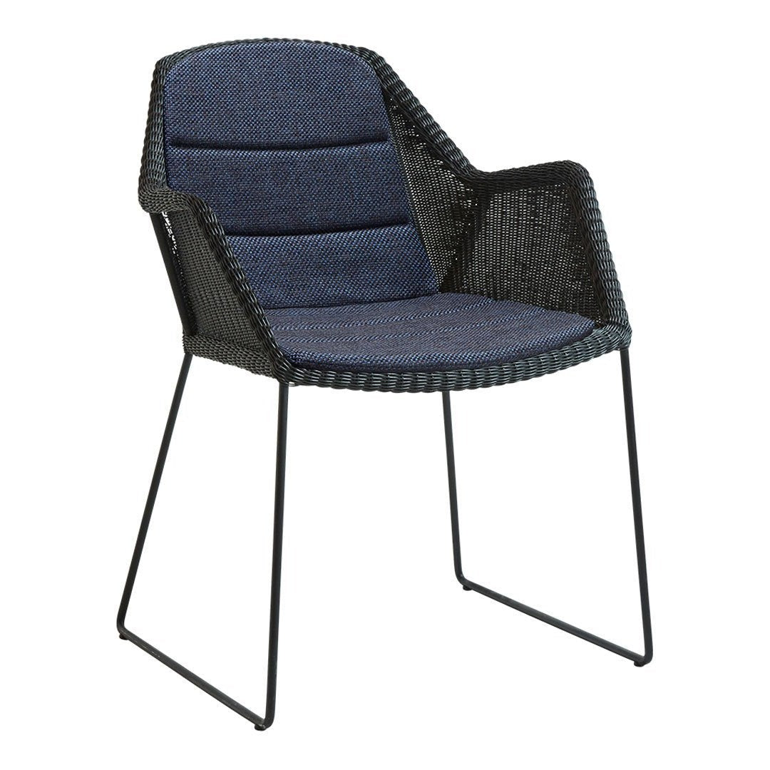 Stylish black wicker chair with navy blue cushioned seat and backrest, perfect for modern decor.