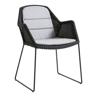 Modern black wicker chair with a sleek gray cushion, featuring a minimalist design and clean lines.