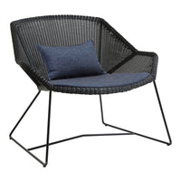Black woven chair with a navy blue cushion, featuring a modern geometric design and sleek metal legs.