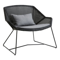 Stylish black woven chair with a grey cushion, featuring a modern geometric pattern. Perfect for contemporary decor.