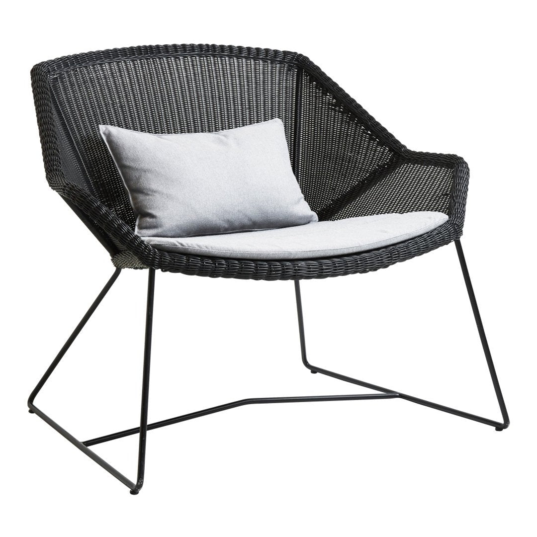 Black woven armchair with a light gray cushion, featuring sleek metal legs and a modern geometric pattern.