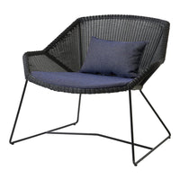 Black woven chair with a navy blue cushion, showcasing a modern and minimalist design.