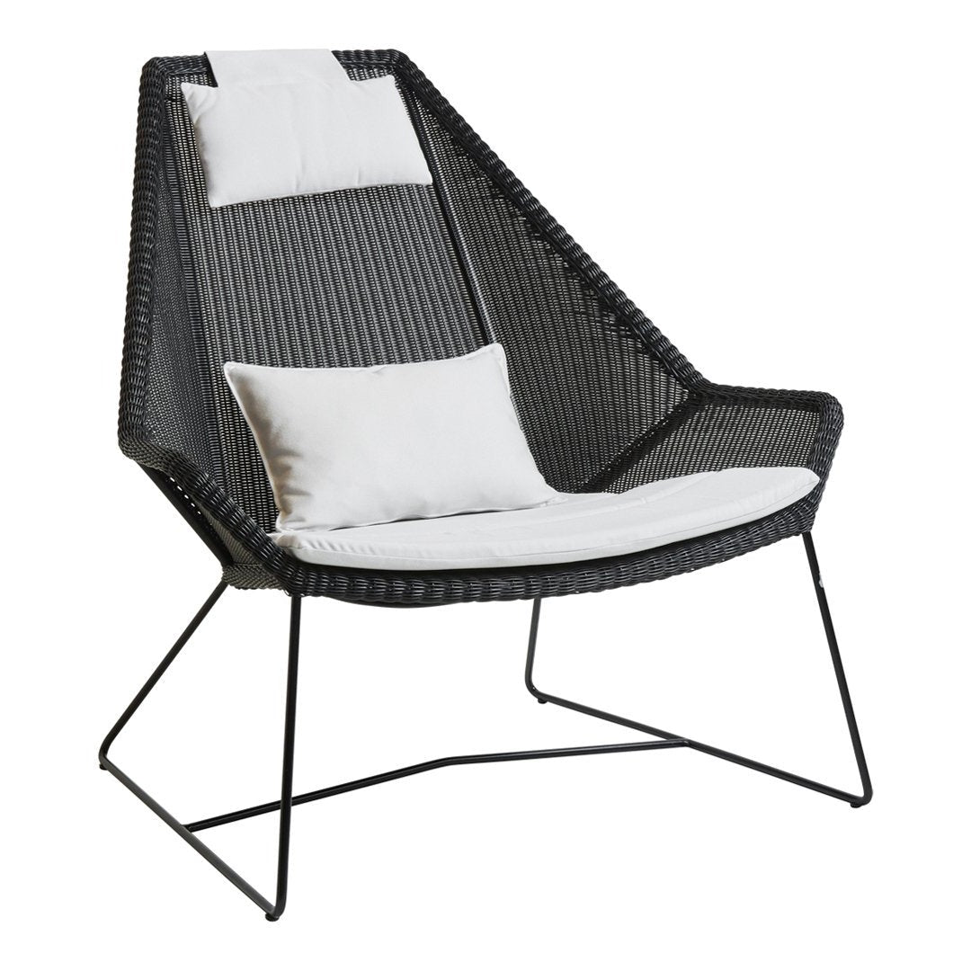 Modern black woven lounge chair with white cushions, featuring a sleek geometric pattern and minimalist design.