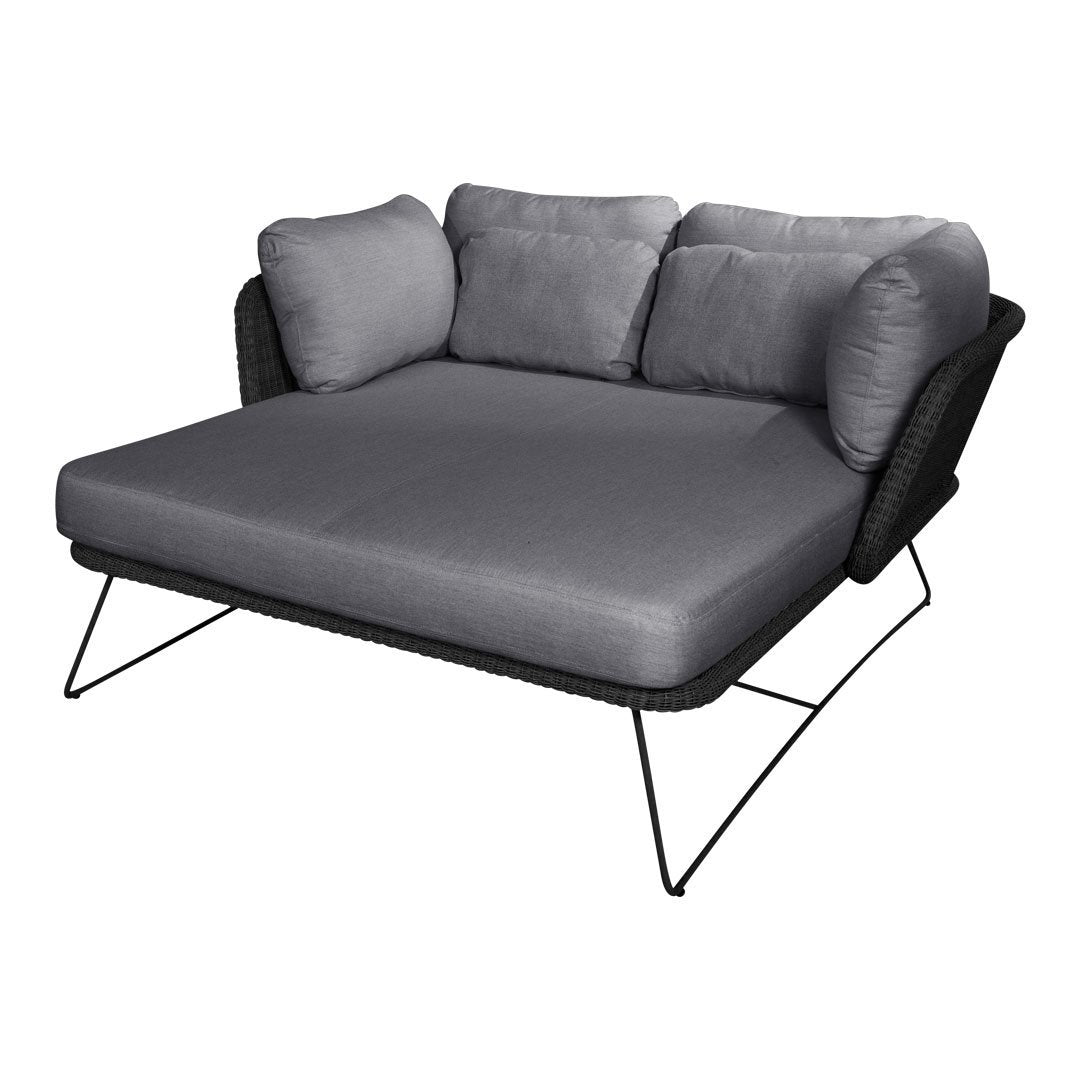 Gray upholstered outdoor sofa with black woven base and sleek metal legs, ideal for modern patio decor.