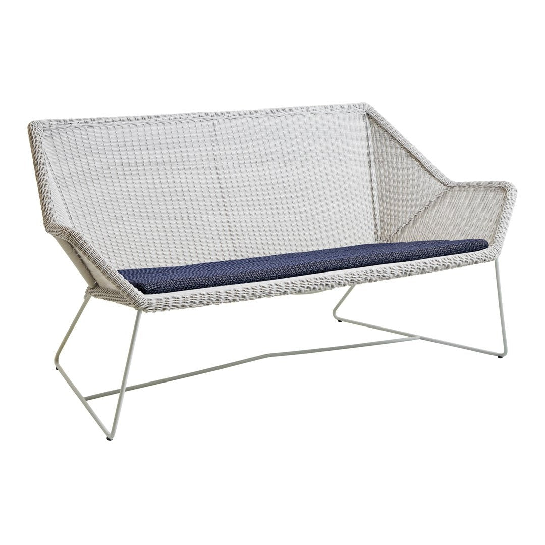 White woven loveseat with a deep navy cushion, featuring a modern geometric design and sleek metal legs.
