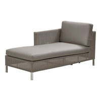 Gray wicker chaise lounge with a smooth, minimalist design and simple, neutral-colored cushions.