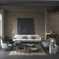 "Modern living room featuring gray furniture with geometric patterns on a vintage rug against a rustic brick wall."