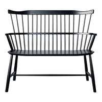 Black wooden bench with sleek vertical slats and a minimalist design, showcasing a modern, monochromatic aesthetic.
