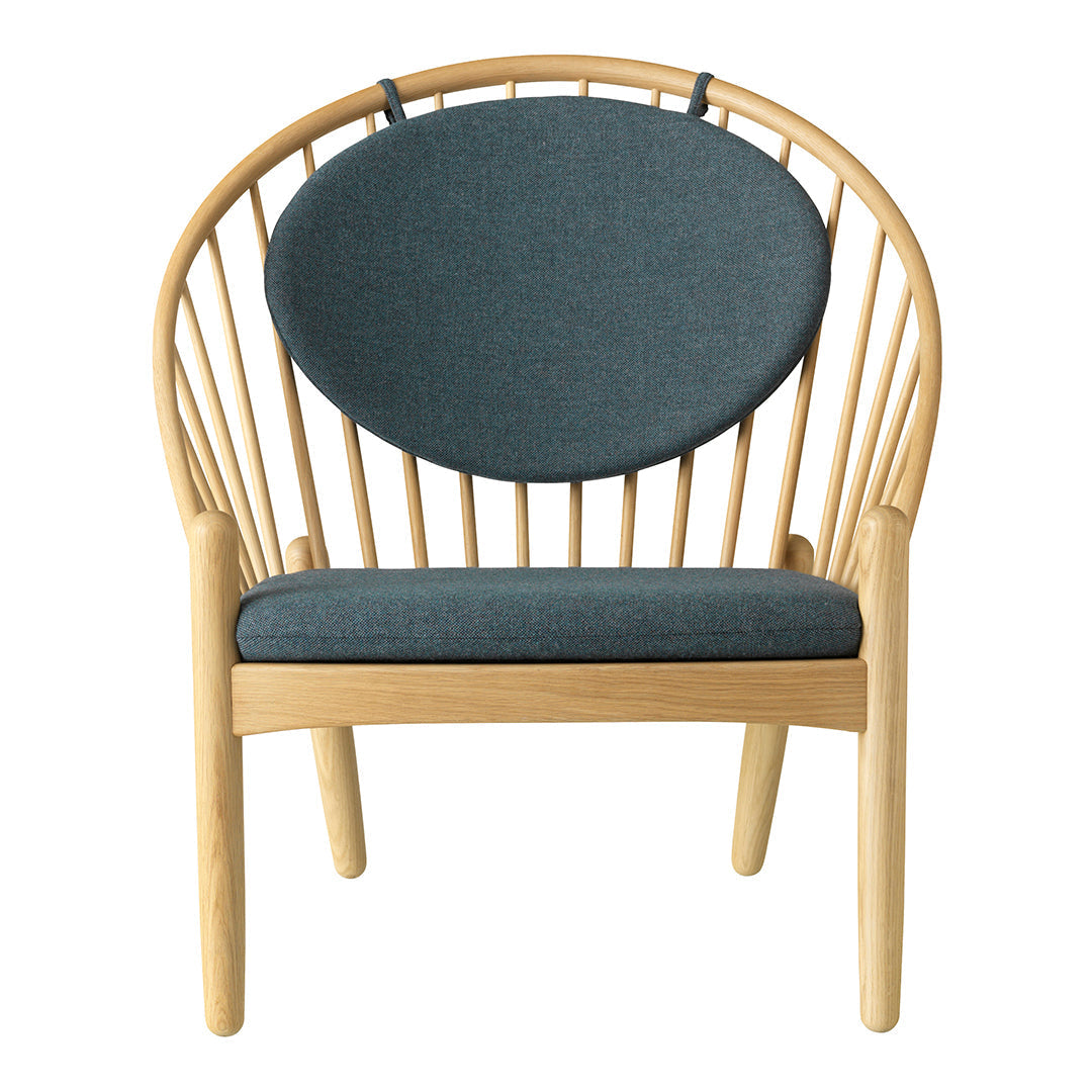 Stylish wooden chair with a round dark teal cushion and natural wood finish, featuring sleek, minimalist design.