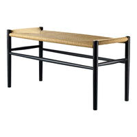 Black frame bench with a natural woven seat, showcasing a minimalist design and organic textures. 