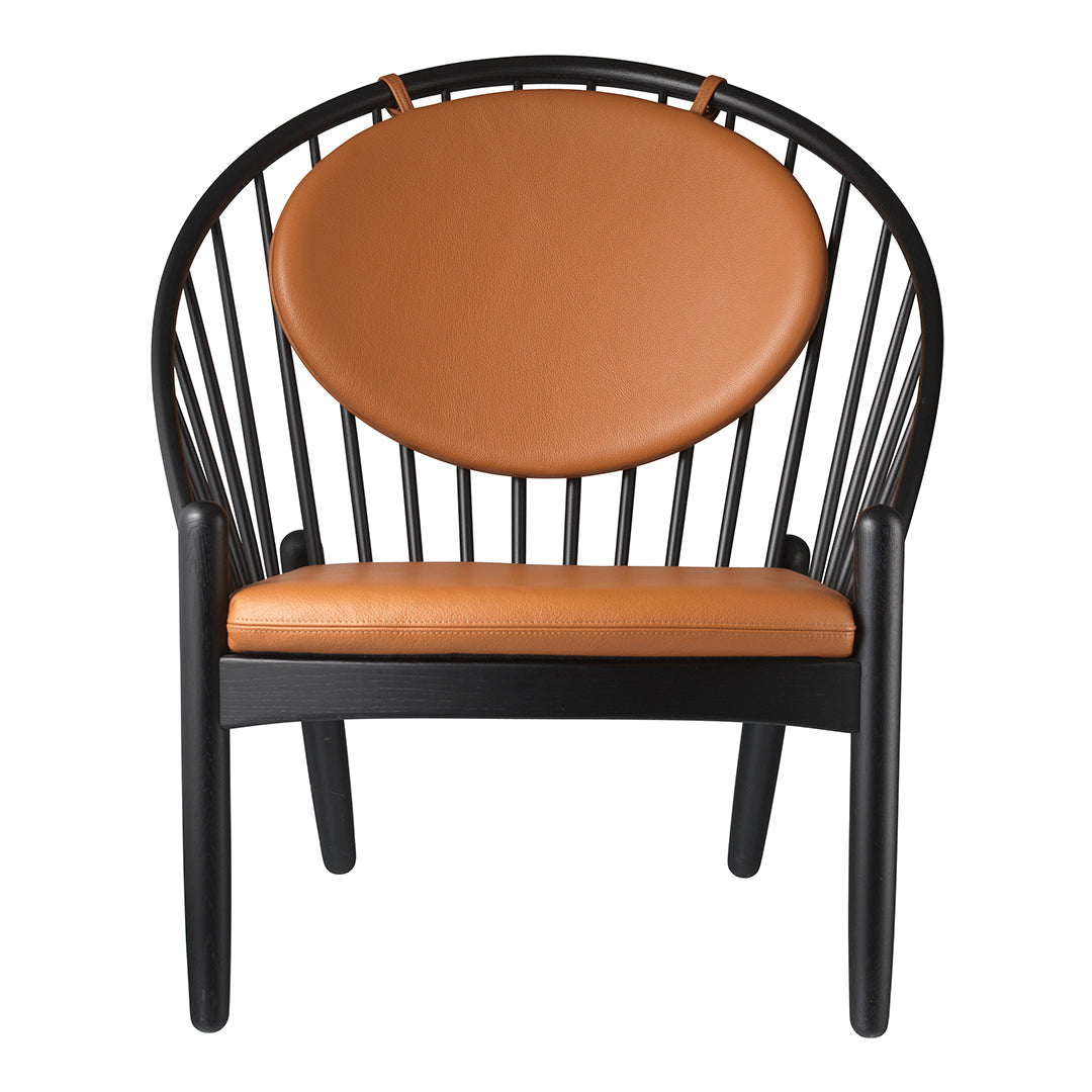 Black wooden chair with a round orange leather seat cushion and a sleek, modern design.