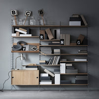 Modern shelving unit featuring a mix of natural wood tones, monochrome books, and geometric patterns.