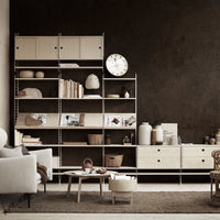 Modern cream shelving unit with subtle wooden textures against a dark, textured wall, featuring neutral decor accents.
