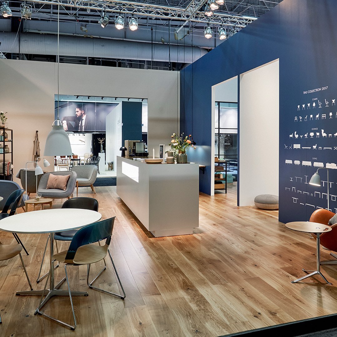 Modern indoor space featuring a blue accent wall, light wood flooring, and stylish furniture in muted tones.