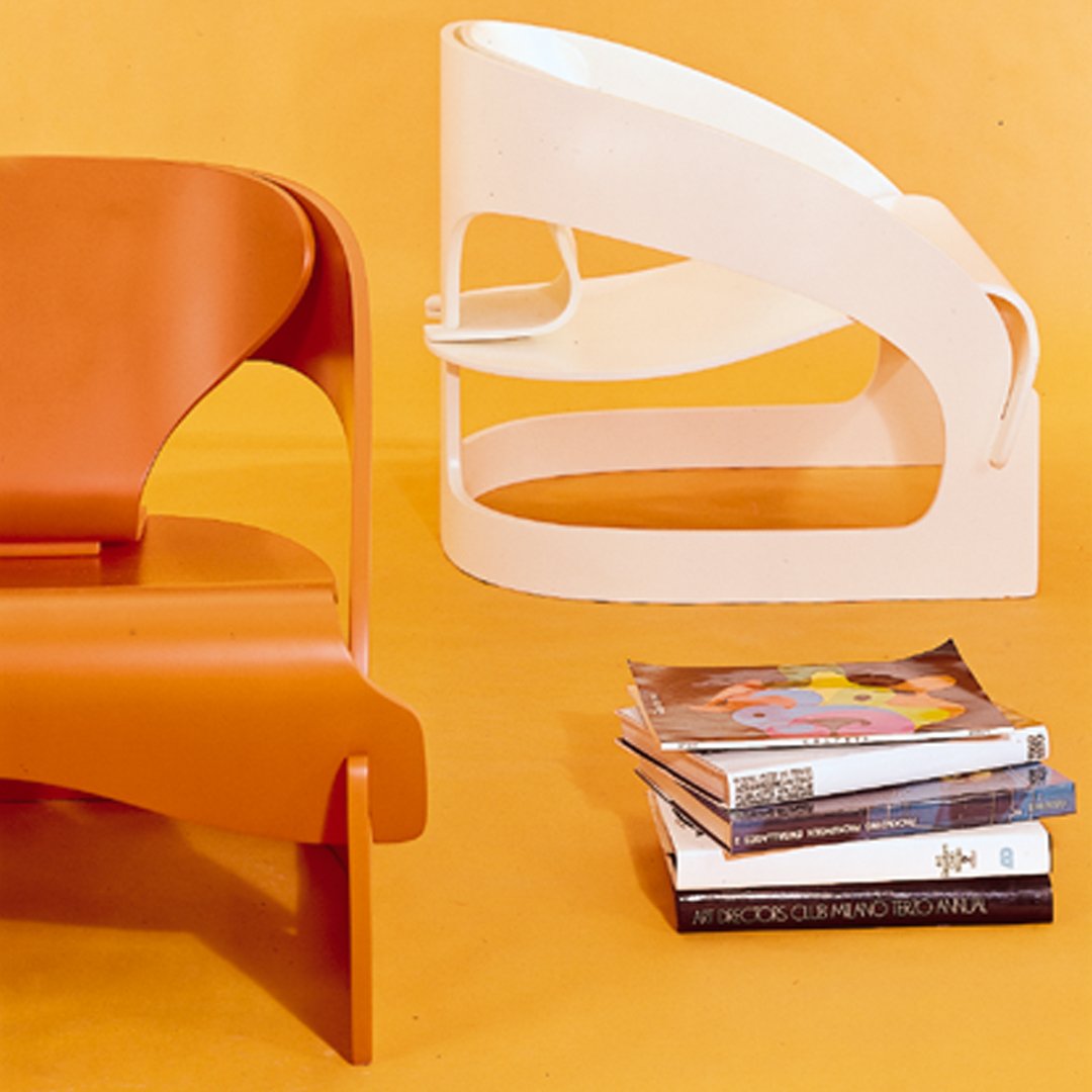 Contemporary orange and white chairs against a bright yellow background, showcasing sleek curves and geometric shapes.