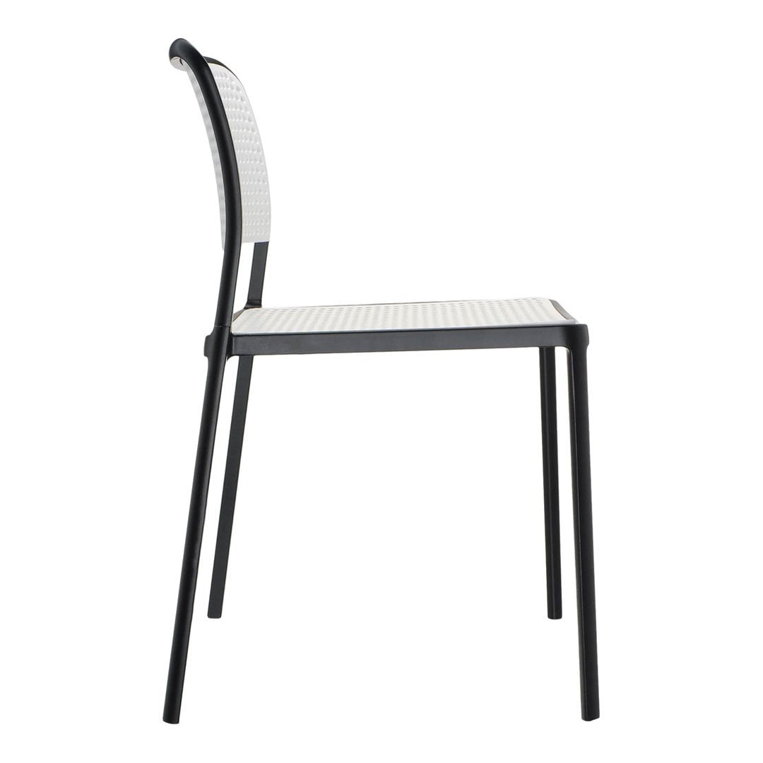 Black chair with a textured white seat and backrest, featuring a sleek, modern design and minimalist pattern.