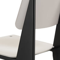 Modern black and white chair with a sleek design, featuring a smooth white seat and a contrasting black frame.