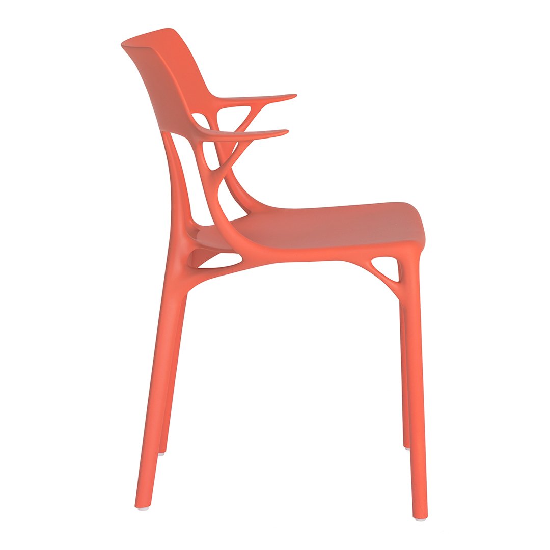 Coral-colored chair with a sleek, modern design and unique cutout patterns, ideal for contemporary decor.