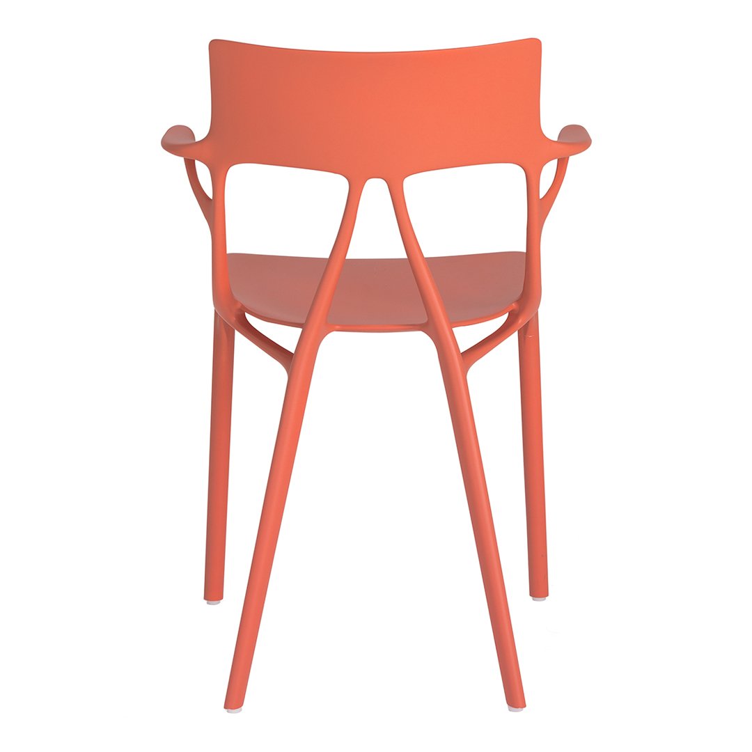 Coral orange plastic chair with a sleek, modern design and minimalist pattern. Perfect for contemporary decor.