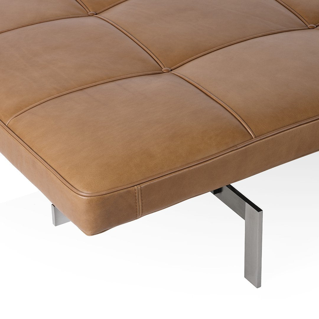 Brown leather cushion with a quilted pattern, featuring sleek silver metal legs.