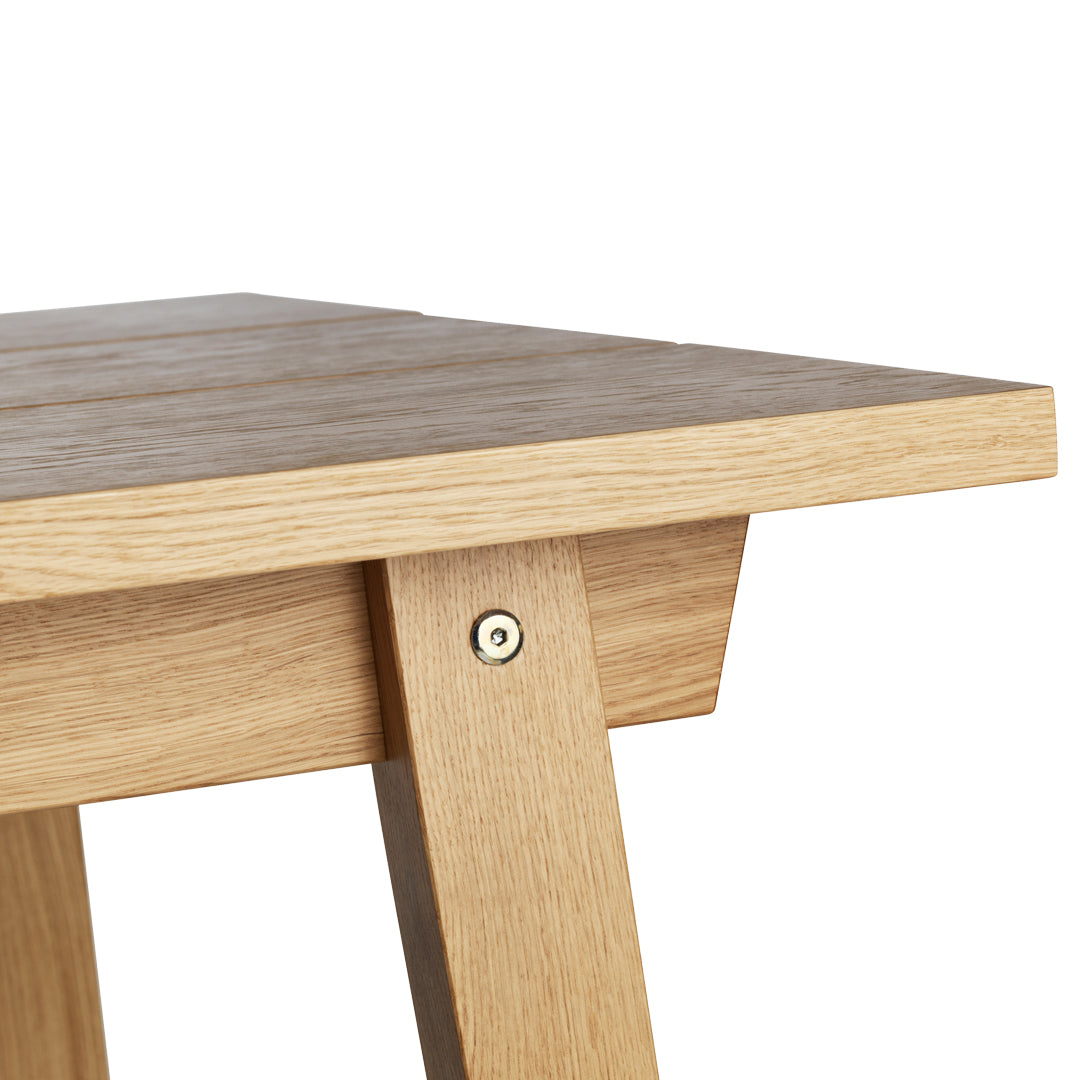 Natural oak wood table with a smooth grain and warm, light brown tones, showcasing a minimalist design.