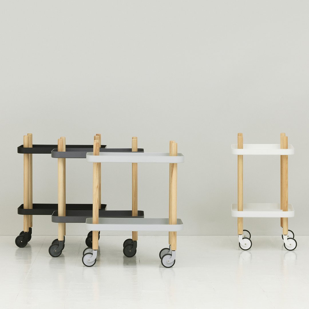 Stylish wheeled carts in black, white, and gray with natural wood accents, featuring a modern minimalist design.