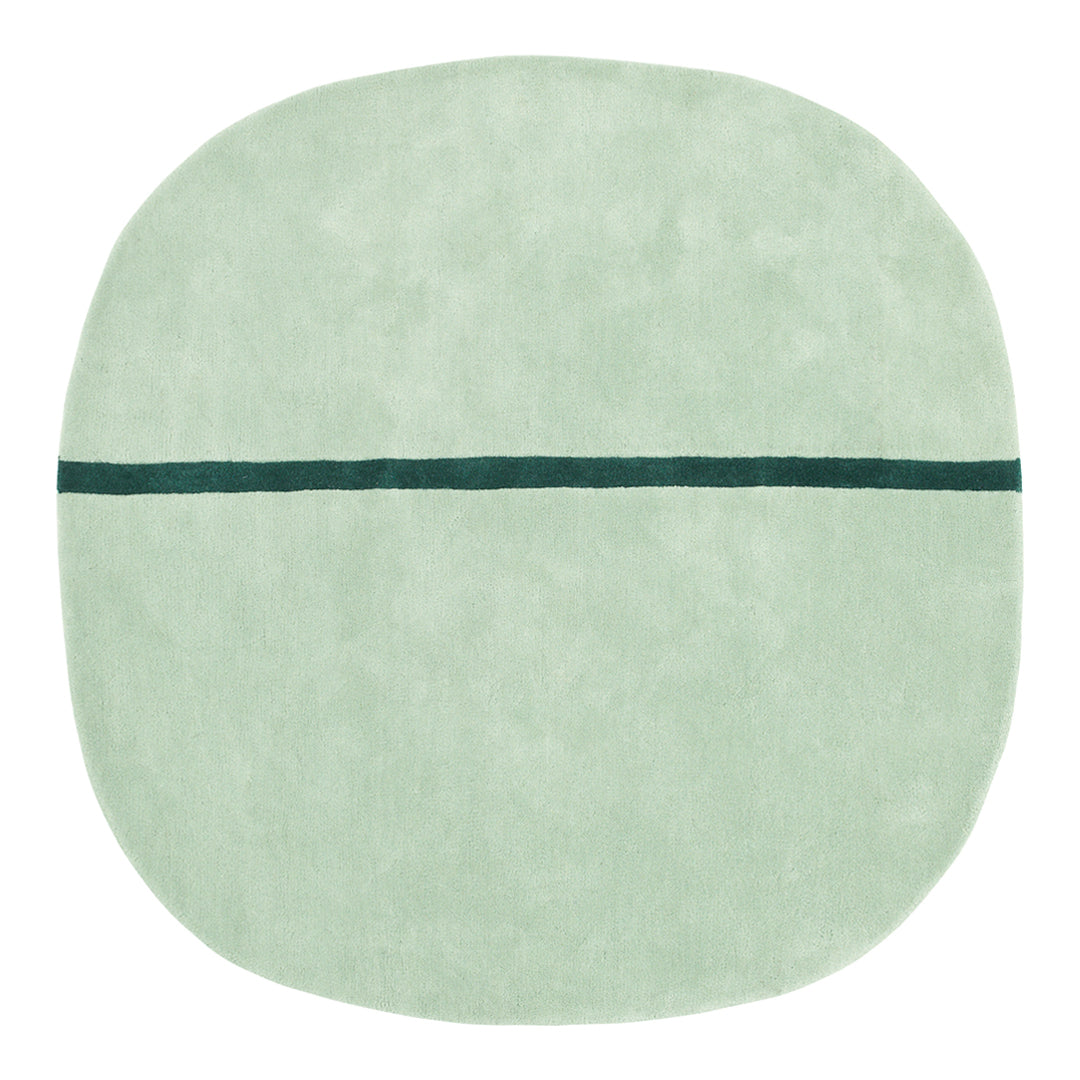 Soft mint green round rug with a contrasting dark teal line pattern across the center.
