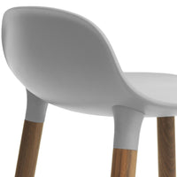 Modern white chair with smooth curves and natural wood legs, showcasing a minimalist design and soft color palette.