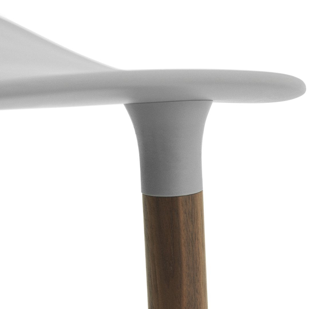 Minimalist white tabletop with a smooth gray edge and a natural wood grain brown leg. Modern design elements.