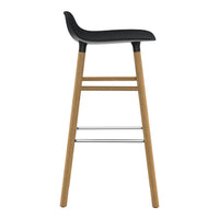 Modern black bar stool with a minimalist design and natural wood legs, featuring clean lines and a sleek finish.