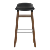Black upholstered bar stool with a wooden frame and silver footrest, featuring a sleek, modern design.