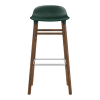 Green plastic seat with a wooden frame and chrome footrest, featuring a minimalist and modern design.