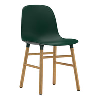 Green molded chair with a sleek design and light wooden legs, perfect for modern interiors.