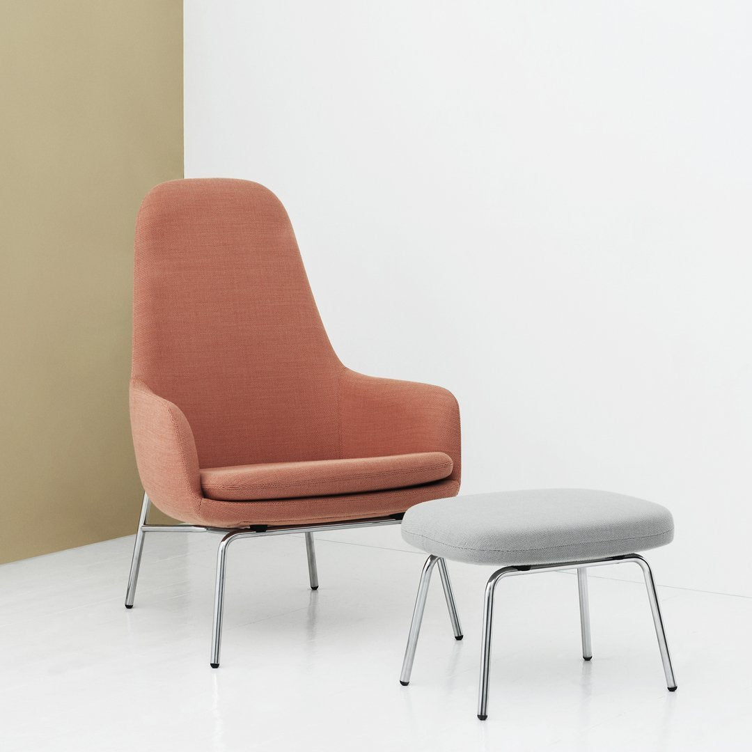 Stylish pink high-back chair and matching light gray ottoman, featuring a clean, modern design on a minimalist background.