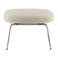Beige upholstered ottoman with a smooth texture and sleek chrome legs, featuring a minimalist design.