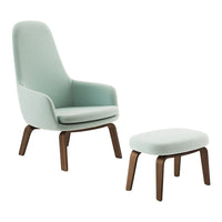 Light mint green upholstered chair and ottoman with stylish wooden legs, offering a modern and minimalistic design.
