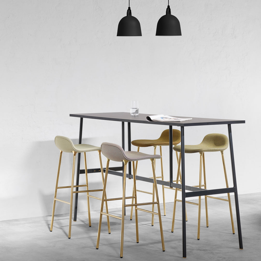 Stylish bar table with black frames, gray and olive green upholstered stools, and black pendant lighting.