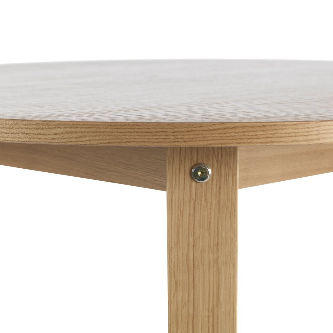 Light wood grain table with a smooth round top and seamless natural finish, featuring a simple, modern design.