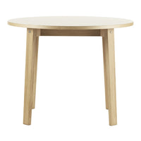 Round table with a smooth white top and natural wood legs, showcasing a minimalistic and modern design.