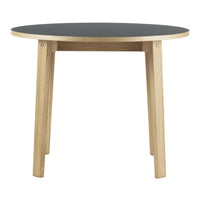 Round table with a black top and natural wood legs, featuring a sleek, modern design. Perfect for any space.