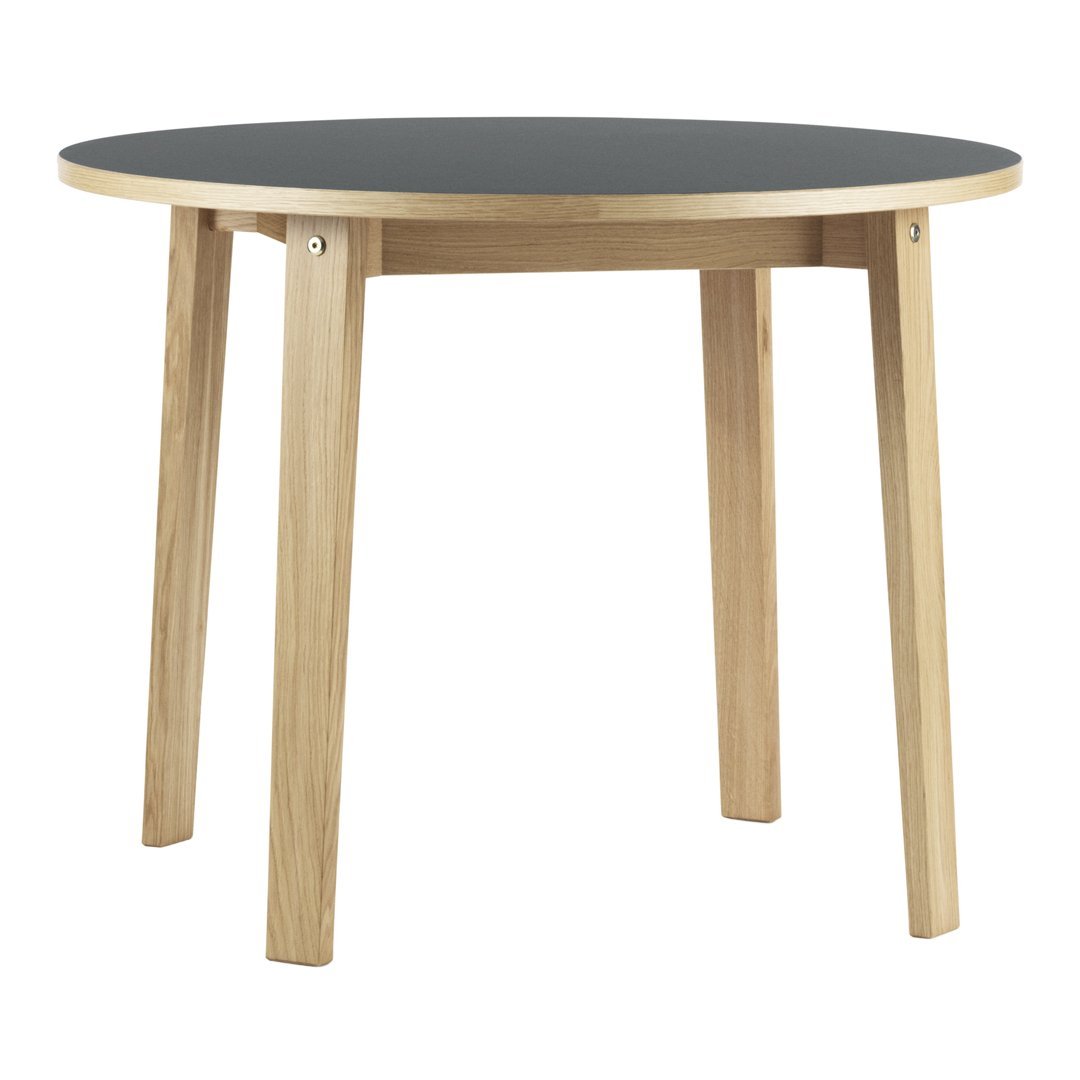Round table with a sleek black top and natural wood legs, featuring a minimalist design and smooth finishes.