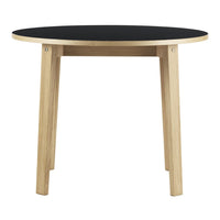 Round table with a sleek black tabletop and natural wood legs, featuring a minimalist design. Perfect for modern spaces.