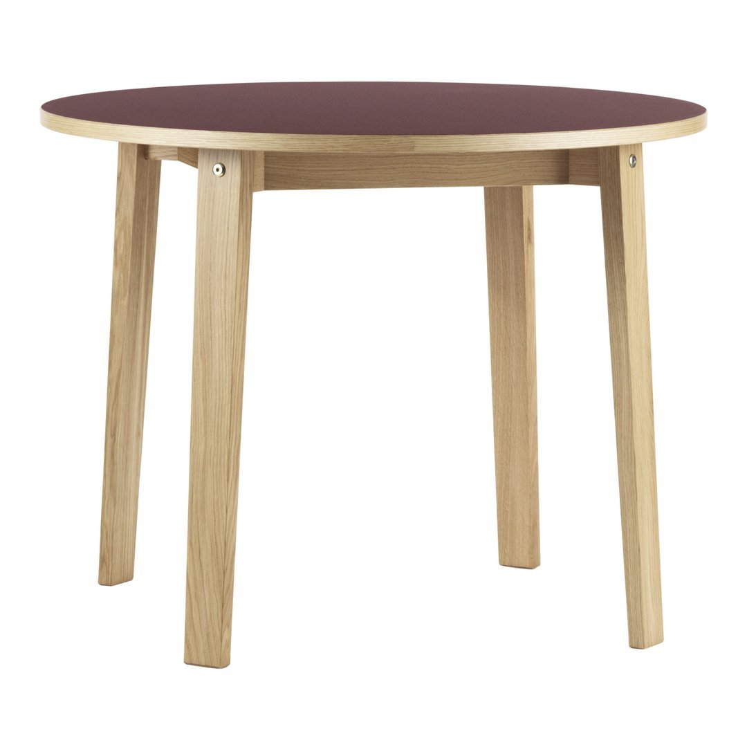 Round table featuring a burgundy top and natural wood legs, perfect for modern decor.