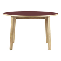 Round table featuring a deep burgundy top and natural wood legs, perfect for modern dining spaces.